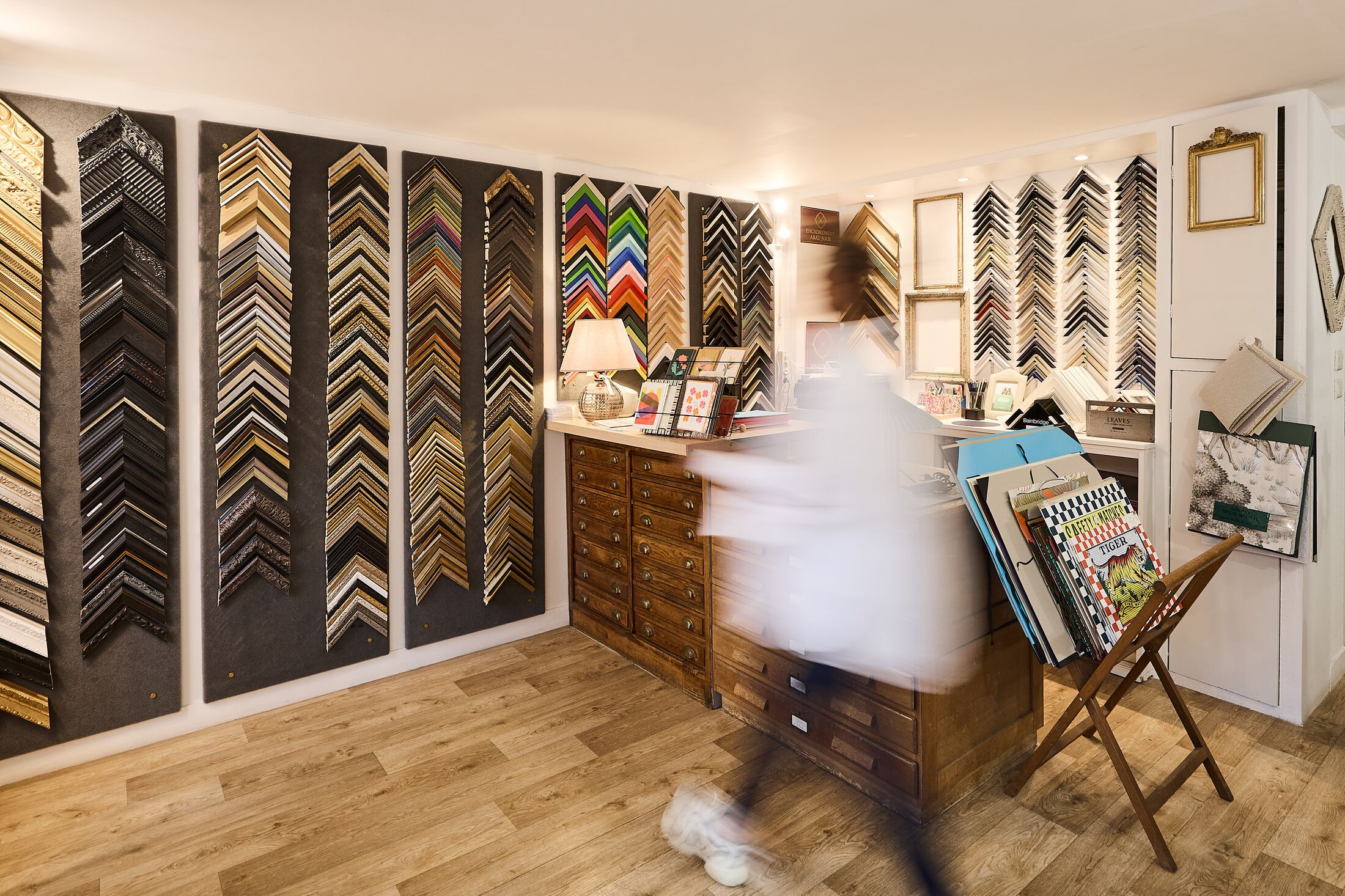 La boutique-atelier, ses murs de baguettes et Sandrine au travail