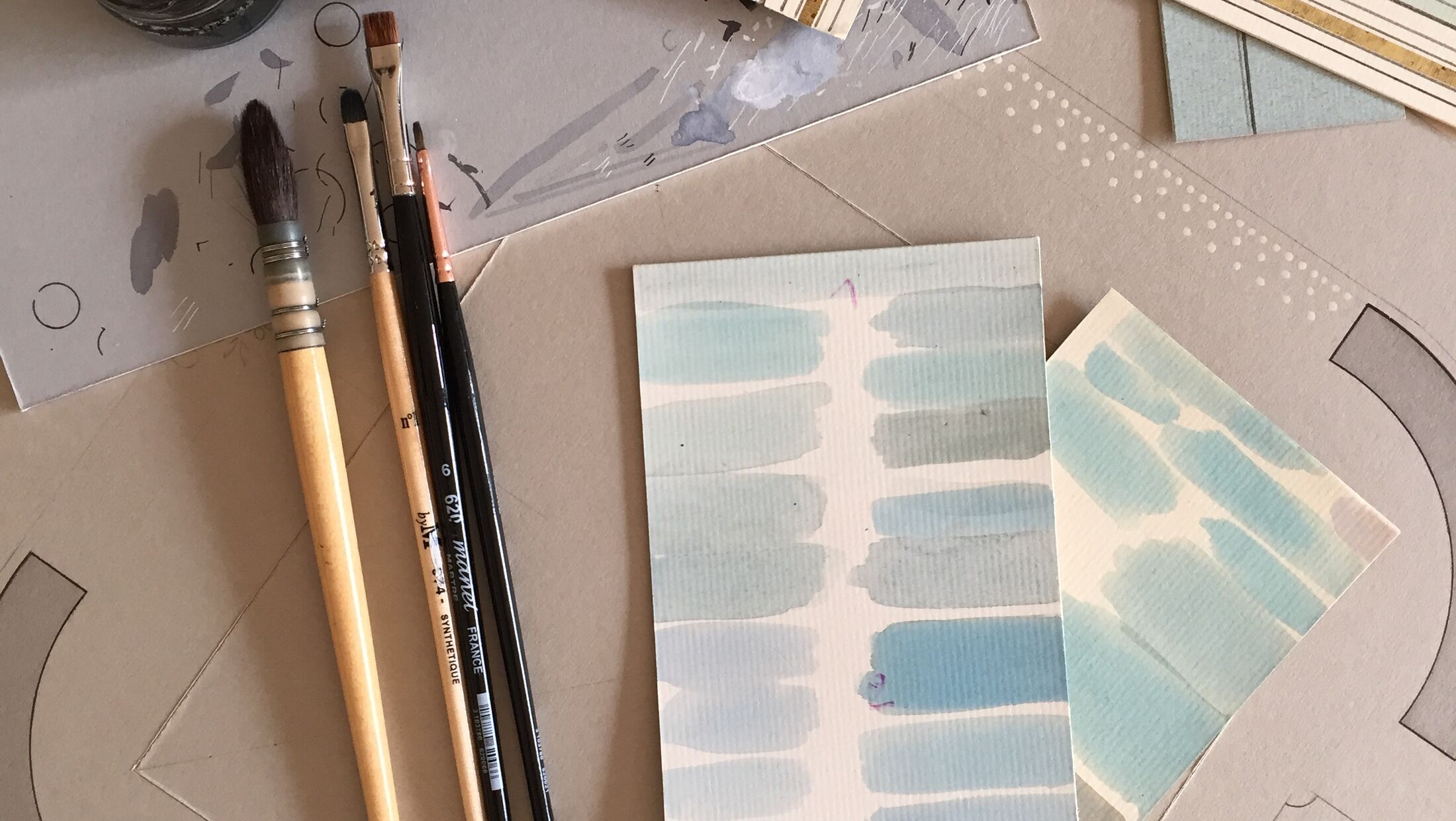 Établi de l'encadreur : pinceaux, gouache et échantillons de passe-partout