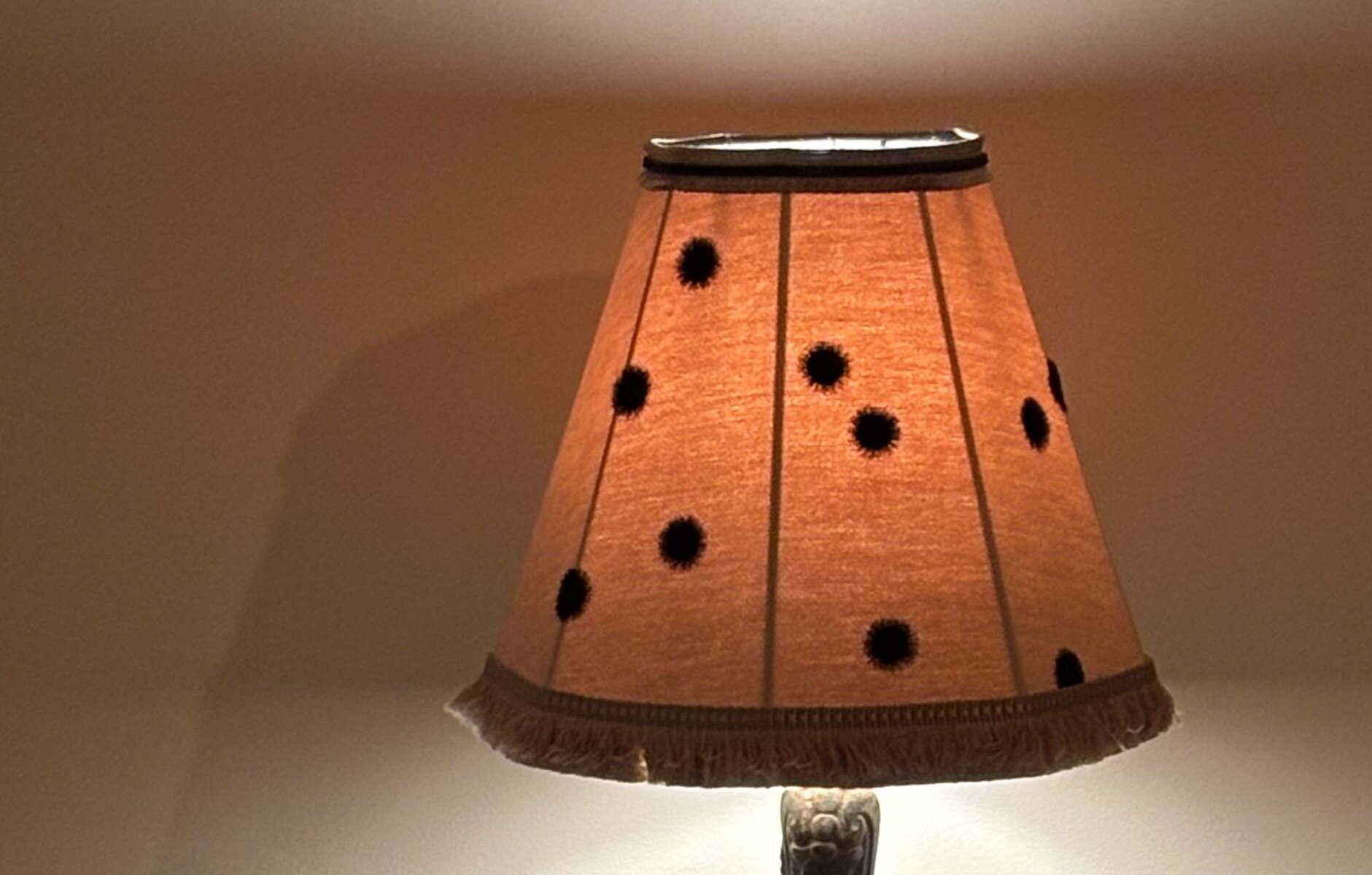 Abat-jour sur mesure allumé, halo de lumière chaude sur le mur